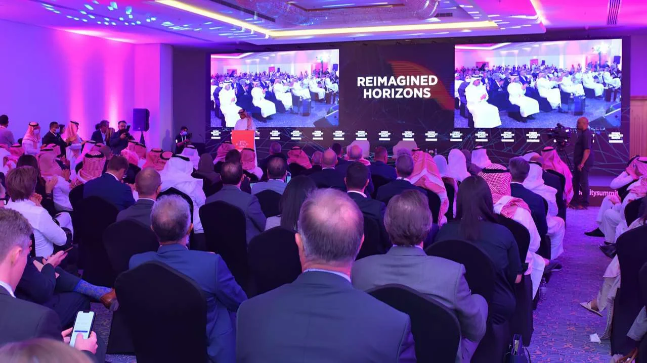 Audience at the Future Hospitality Summit facing a purple-lit stage and presentation screens
